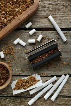 Flat lay composition with roller and tobacco on old wooden table. Making ha.. 写真素材