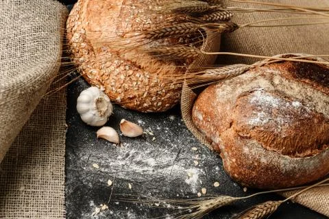 Flat lay composition with a rustic dough lying on a black flour-strewn surfac Stock Photos