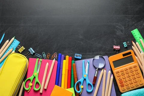 Flat lay composition with scissors and school supplies on dark background. Sp Stock Photos