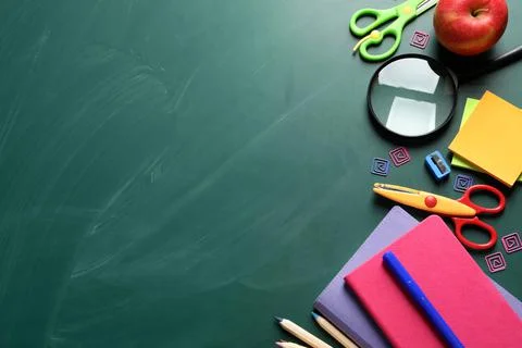 Flat lay composition with scissors and school supplies on chalkboard. Space f Stock Photos