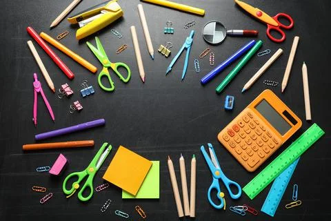 Flat lay composition with scissors and school supplies on dark background. Sp Foto stock