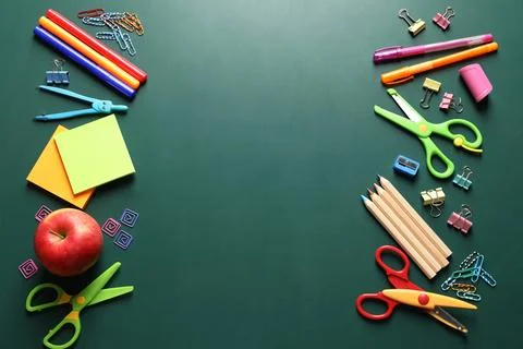 Flat lay composition with scissors and school supplies on chalkboard. Space f Stock Photos