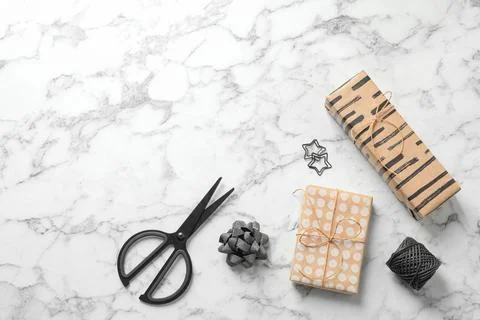 Flat lay composition with scissors and gift boxes on white marble table, spac Stock Photos