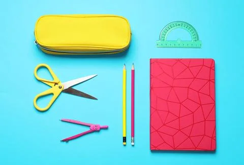 Flat lay composition with scissors and school stationery on light blue backgr Stock Photos