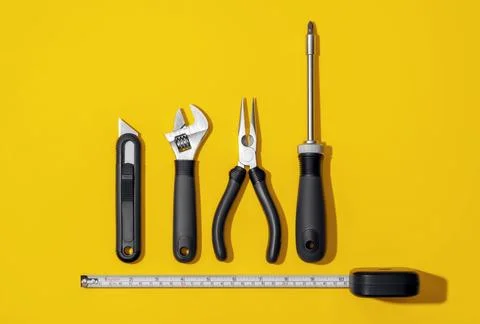 Flat lay composition with set of home repair tools on bright yellow background. Stock Photos