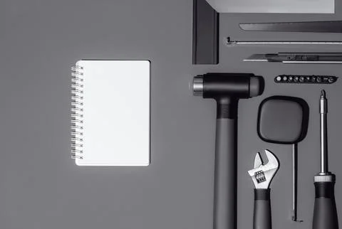 Flat lay composition with set of home repair tools and opened notebook on grey Stock Photos