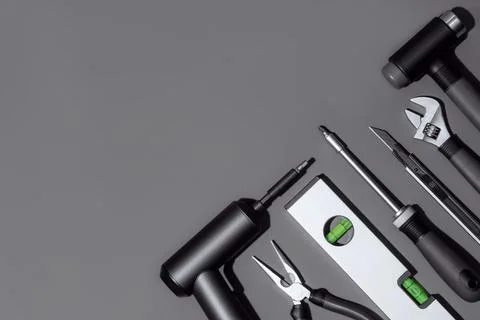 Flat lay composition with set of home repair tools on grey stone background. Stock Photos