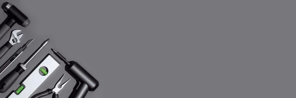 Flat lay composition with set of home repair tools on dark grey background. Stock Photos