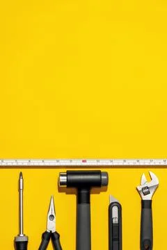 Flat lay composition with set of home repair tools on bright yellow background. Stock Photos