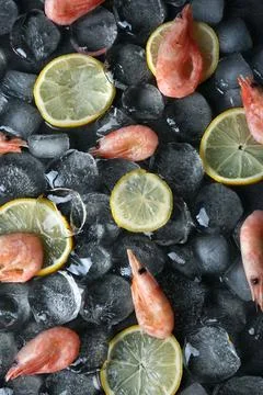 Flat lay composition with shrimps, lemon slices and ice cubes on dark backgro Stockfoto's