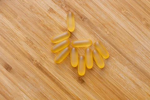 Flat lay composition of soft gel capsules of Omega 3 on a wooden background Stock Photos