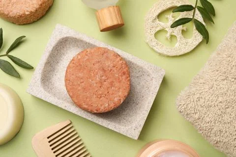 Flat lay composition of solid shampoo bars, loofah and comb on green backgr.. 写真素材