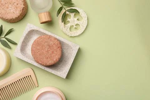 Flat lay composition of solid shampoo bars, loofah and comb on green backgr.. 写真素材
