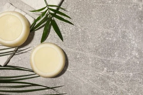 Flat lay composition of solid shampoo bars and leaf on grey background. Spa.. Foto stock