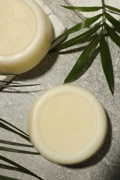 Flat lay composition of solid shampoo bars and leaf on grey background Foto stock