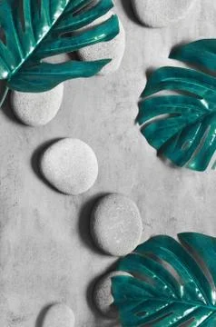 Flat lay composition with spa stones, palm leaves on grey background. Stock Photos
