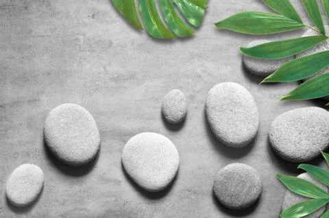 Flat lay composition with spa stones, palm leaves on grey background. Foto stock