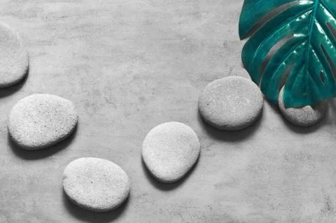 Flat lay composition with spa stones, palm leaves on grey background. Foto stock