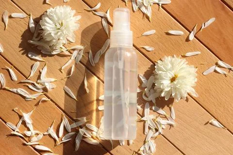 Flat lay composition of a spray bottle surrounded by fresh white meadow flowers Stock Photos