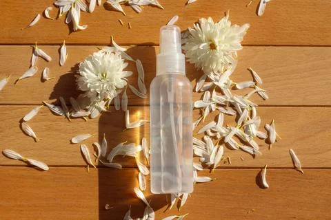 Flat lay composition of a spray bottle surrounded by fresh white meadow flowers Stock Photos