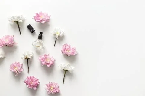 Flat lay composition with spring flowers and perfume jar on white background Stock Photos