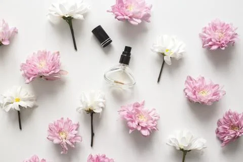 Flat lay composition with spring flowers and perfume jar on white background Stock Photos