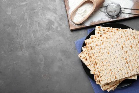Flat lay composition with stack of traditional matzos on grey table. Space fo 스톡 사진