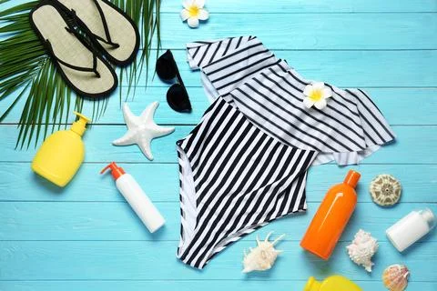 Flat lay composition with striped swimsuit and beach accessories on blue wood Foto stock
