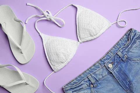 Flat lay composition with stylish beach accessories on lilac background Foto stock