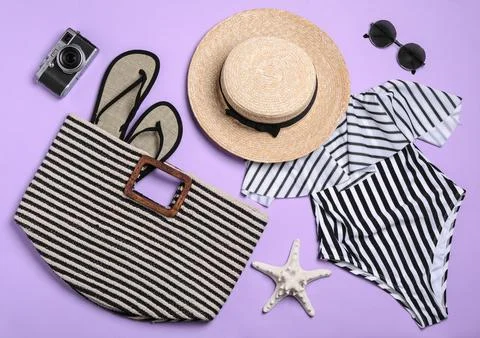 Flat lay composition with stylish beach accessories on lilac background Foto stock