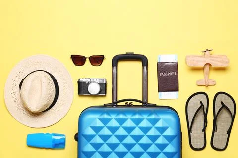 Flat lay composition with suitcase and beach objects on yellow background 스톡 사진