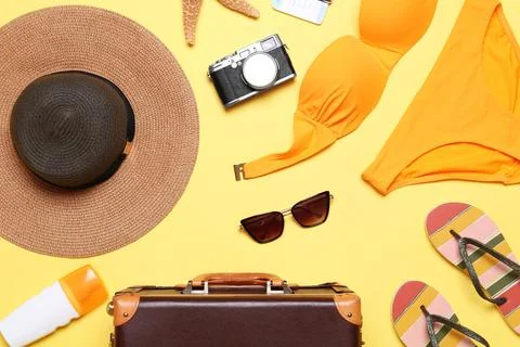 Flat lay composition with suitcase and beach objects on yellow background 스톡 사진