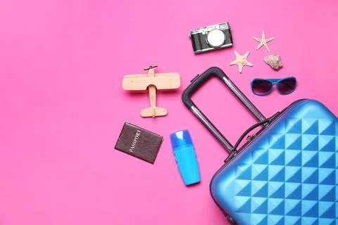Flat lay composition with suitcase and beach objects on pink background. Spac Stock Photos