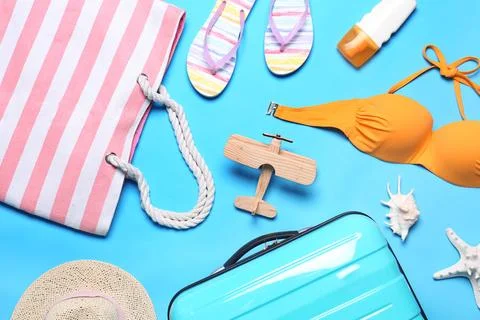 Flat lay composition with suitcase and beach objects on blue background 스톡 사진