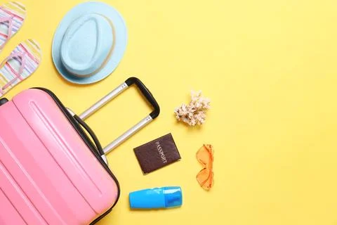 Flat lay composition with suitcase and beach objects on yellow background. Sp Fotos de archivo