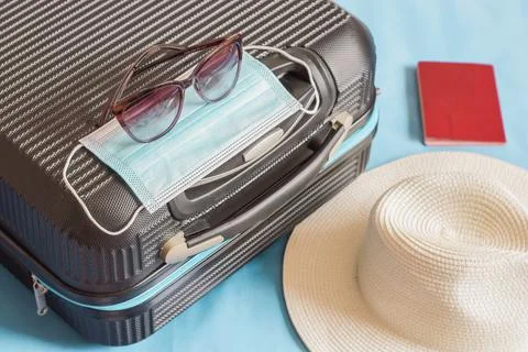 Flat lay composition with suitcase, protective mask,hat,glasses,passport, spa Stock Photos