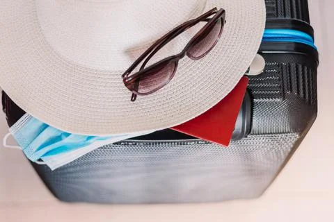 Flat lay composition with suitcase, protective mask,hat,glasses,passport, spa Stock Photos