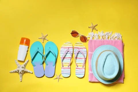 Flat lay composition with summer beach accessories on yellow background. Spac 스톡 사진