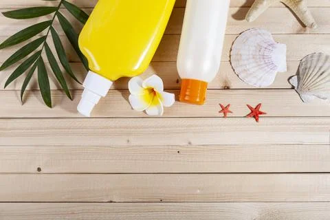 Flat lay composition with sunscreen and seashells on wooden background. Stock Photos