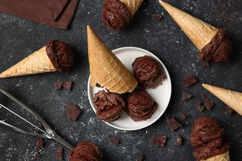 Flat lay composition with tasty ice cream scoops in waffle cones on dark te.. Stock Photos