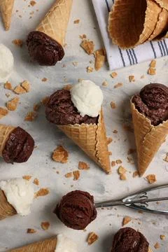 Flat lay composition with tasty ice cream scoops in waffle cones on light t.. Stock Photos