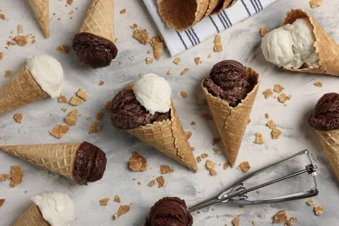 Flat lay composition with tasty ice cream scoops in waffle cones on light t.. Stock Photos