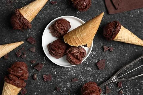 Flat lay composition with tasty ice cream scoops in waffle cones on dark te.. Stock Photos
