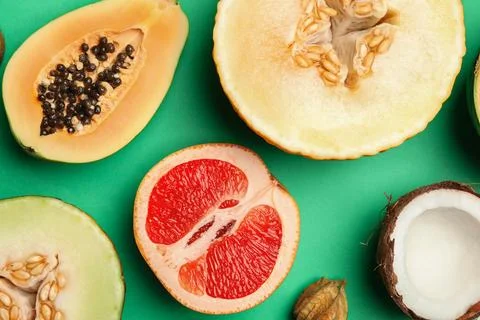 Flat lay composition with tasty melon and fresh tropical fruits on green back Foto stock