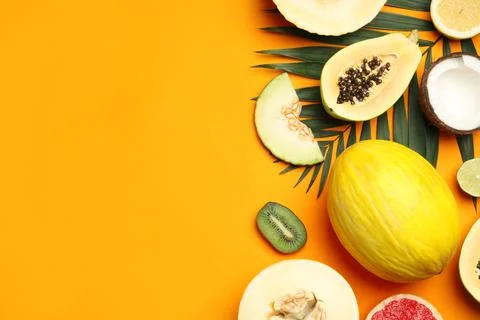 Flat lay composition with tasty melon and fresh tropical fruits on orange bac Foto stock
