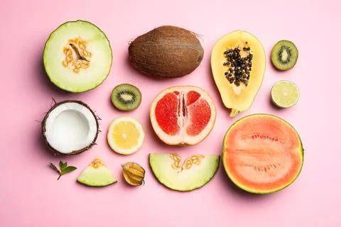 Flat lay composition with tasty melon and fresh tropical fruits on pink backg Stock Photos