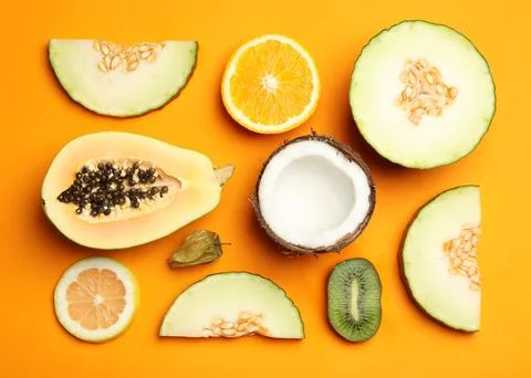Flat lay composition with tasty melon and fresh tropical fruits on orange bac Foto stock