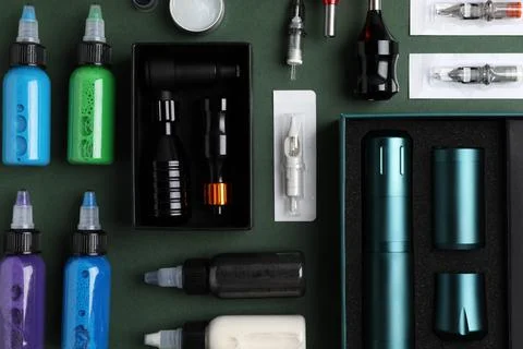 Flat lay composition with tattoo equipment on dark green background 스톡 사진