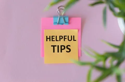 Flat lay composition with text Helpful Tips in yellow paper on white pink tab Stock Photos