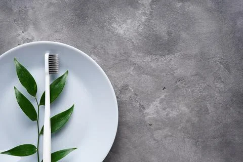 Flat lay composition toothbrush with plate on a gray background with space fo Foto stock